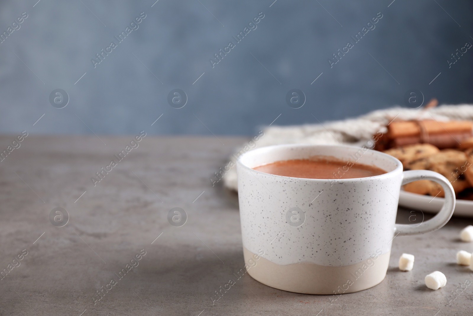 Photo of Cup of delicious hot cocoa on grey table, space for text