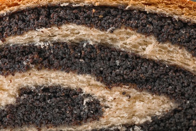 Photo of Tasty sweet bun with poppy seeds as background, closeup view