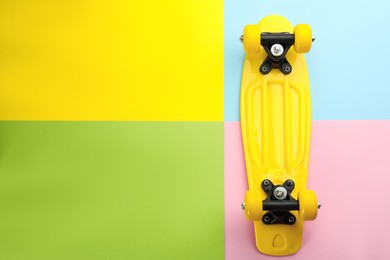 Yellow skateboard on color background, top view. Space for text