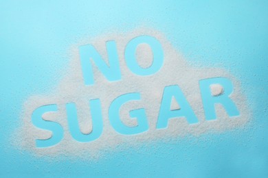 Photo of Words No Sugar on light blue background, top view