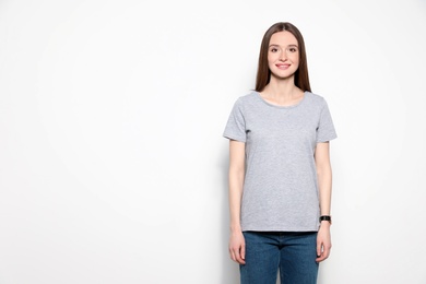 Photo of Young woman in t-shirt on light background. Mock up for design