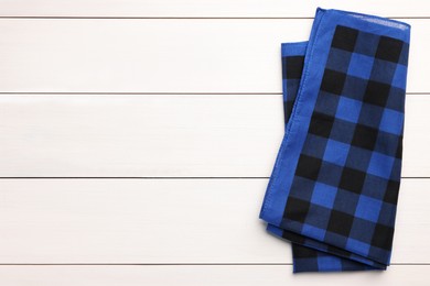 Photo of Folded blue checkered bandana on white wooden table, top view. Space for text