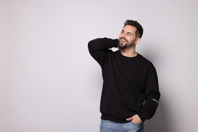 Happy man in stylish sweater on white background, space for text