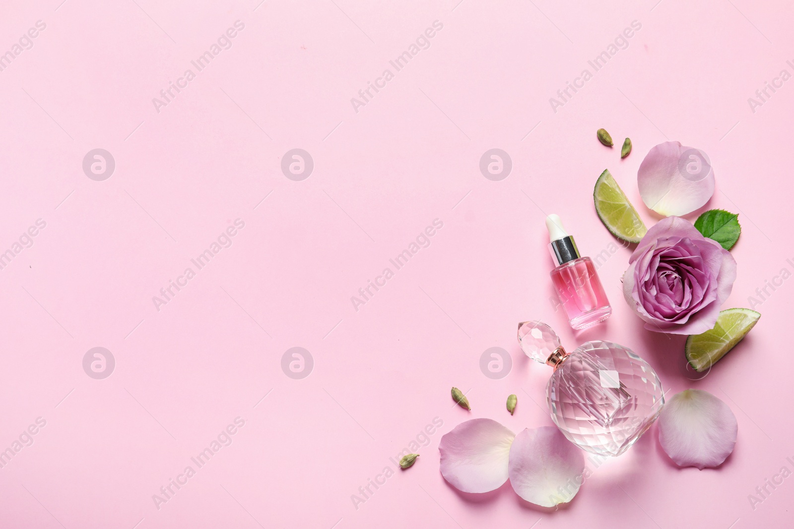 Photo of Flat lay composition with elegant perfume on pink background, space for text