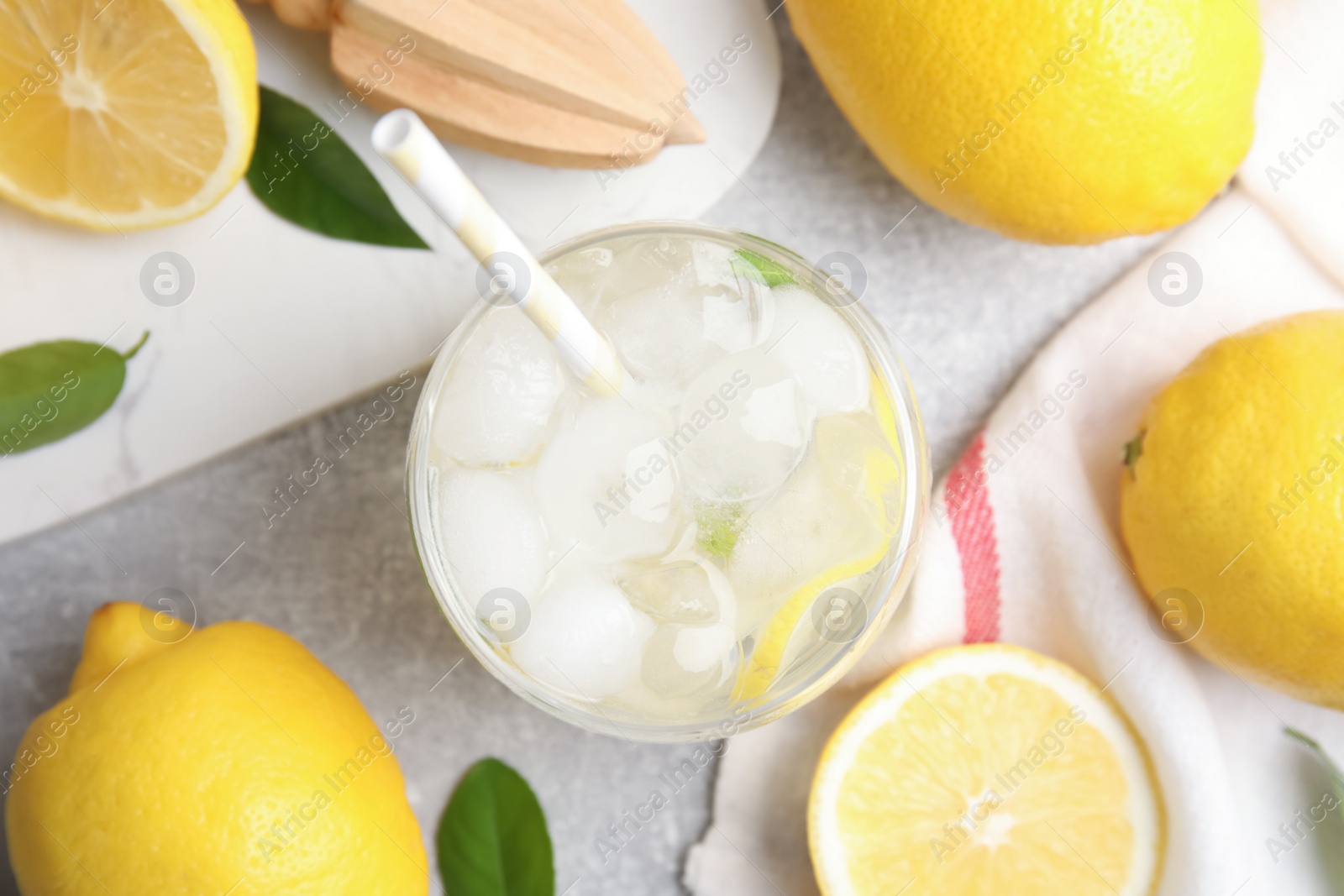 Photo of Cool freshly made lemonade and fruits on light grey table, flat lay