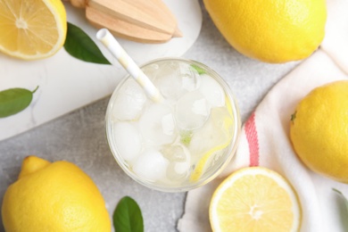 Photo of Cool freshly made lemonade and fruits on light grey table, flat lay