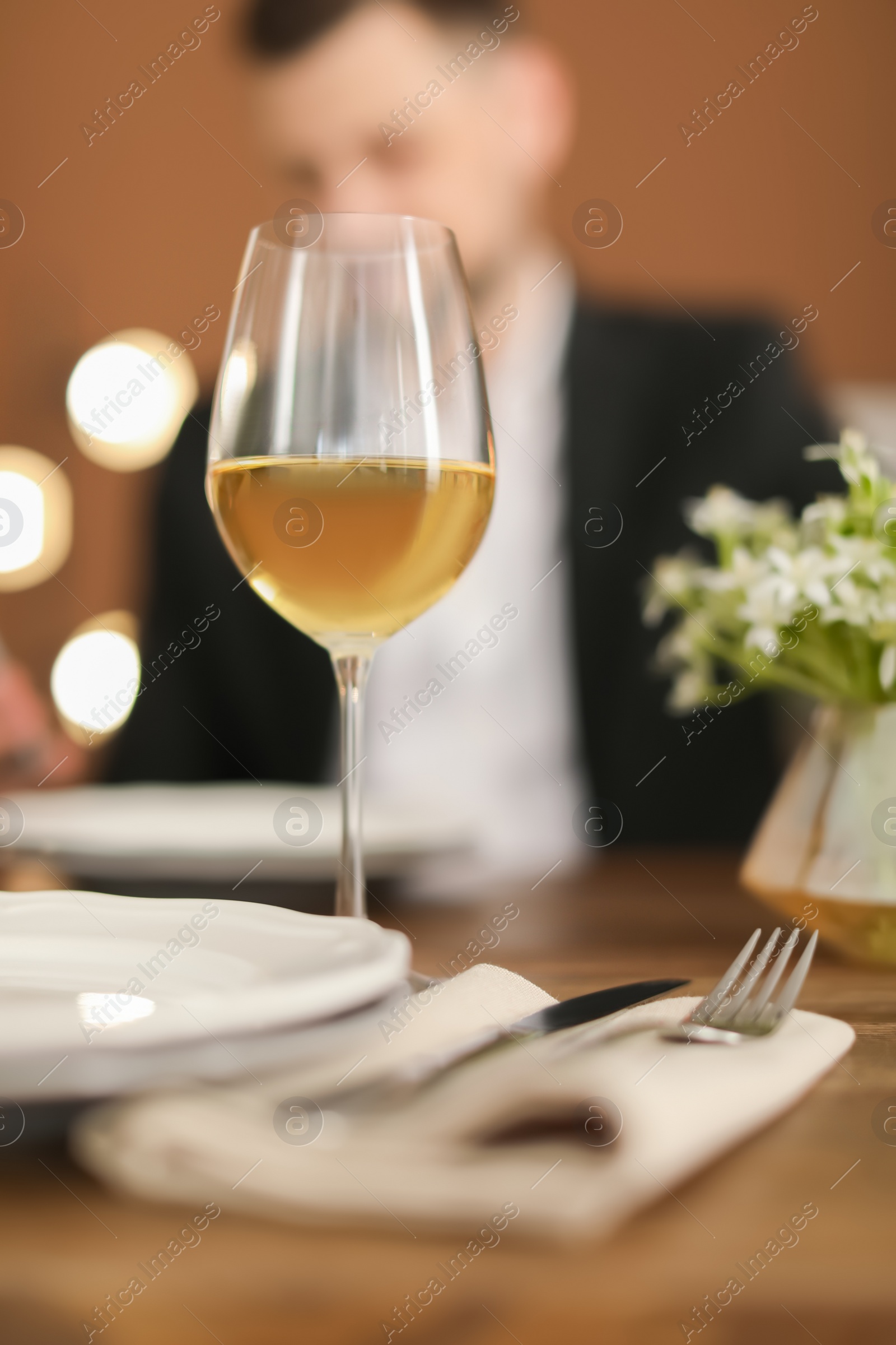 Photo of Glass of delicious wine and blurred man on background