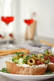 Plate of delicious bruschettas with prosciutto on grey wooden table