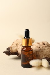 Composition with bottle of cosmetic serum on beige background