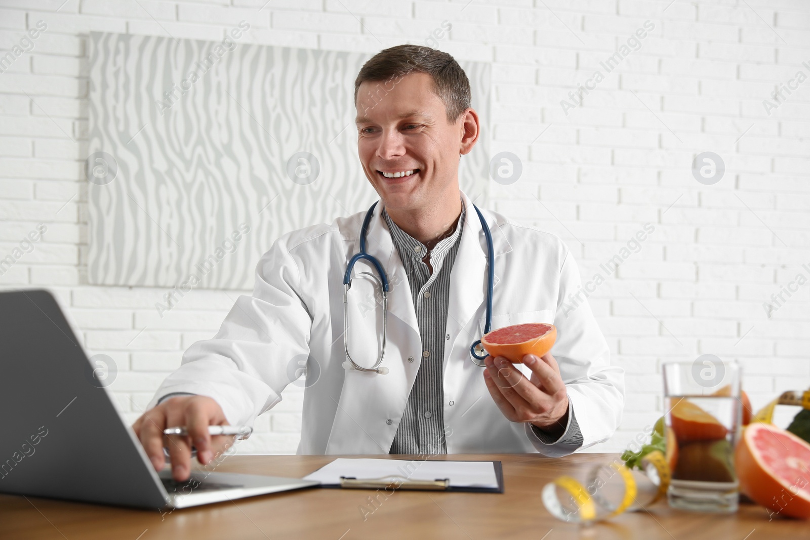 Photo of Nutritionist working with laptop at desk in office