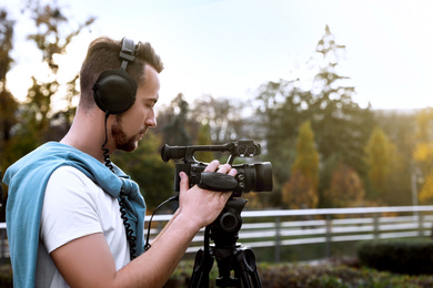 Image of Video operator with professional camera working outdoors