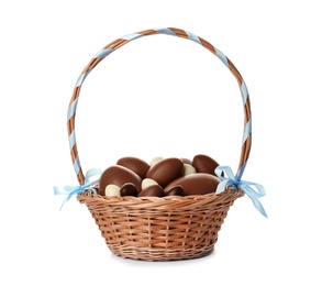 Photo of Wicker basket with chocolate Easter eggs on white background