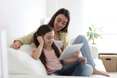 Photo of Mother and daughter reading E-book together at home