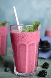 Photo of Tasty fresh milk shake with berries on light blue wooden table, closeup