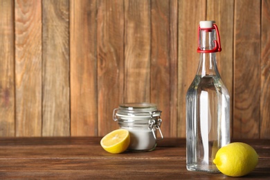 Photo of Composition with vinegar, lemons and baking soda on table. Space for text