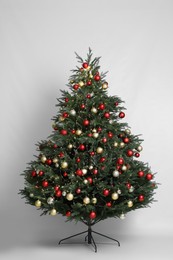 Photo of Beautiful Christmas tree with shiny baubles on white background