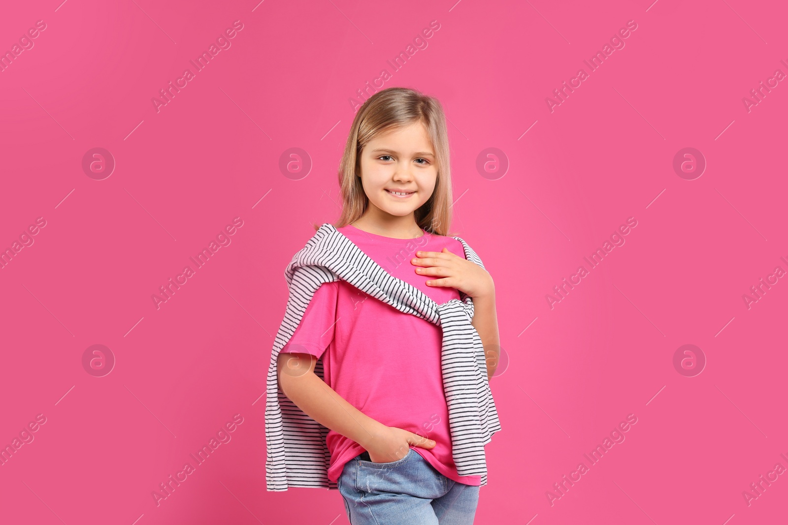 Photo of Cute little girl posing on pink background