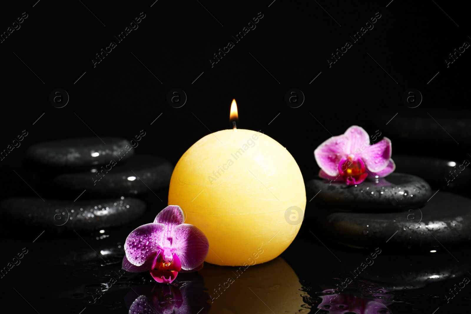 Photo of Composition with candle and spa stones on black background