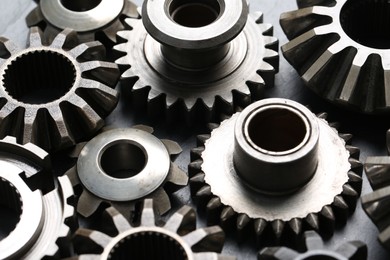 Photo of Many different stainless steel gears on grey background, closeup