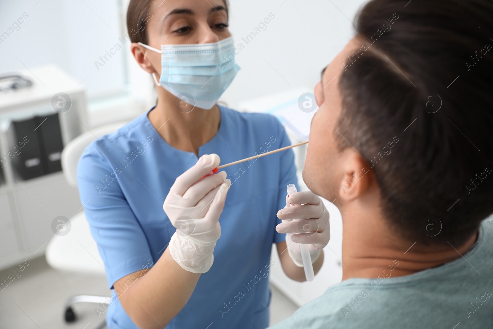 Photo of Doctor taking sample for DNA test from man in clinic