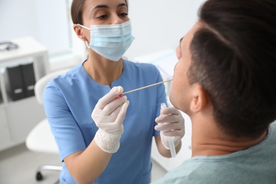 Doctor taking sample for DNA test from man in clinic