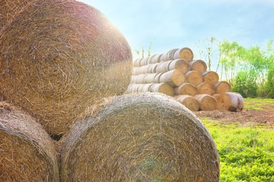 Photo of Many hay bales outdoors on sunny day, closeup