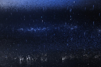 Photo of Water drops falling on color background. Rainy weather