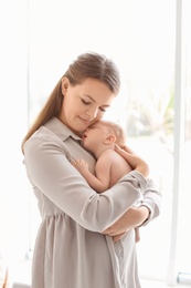 Photo of Young mother with her newborn baby at home