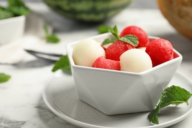 Bowl with melon and watermelon balls on table