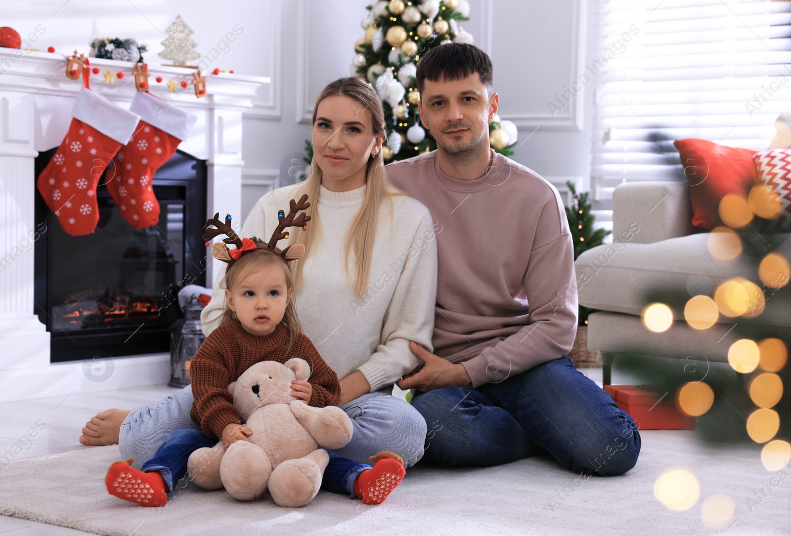 Photo of Happy family in room decorated for Christmas