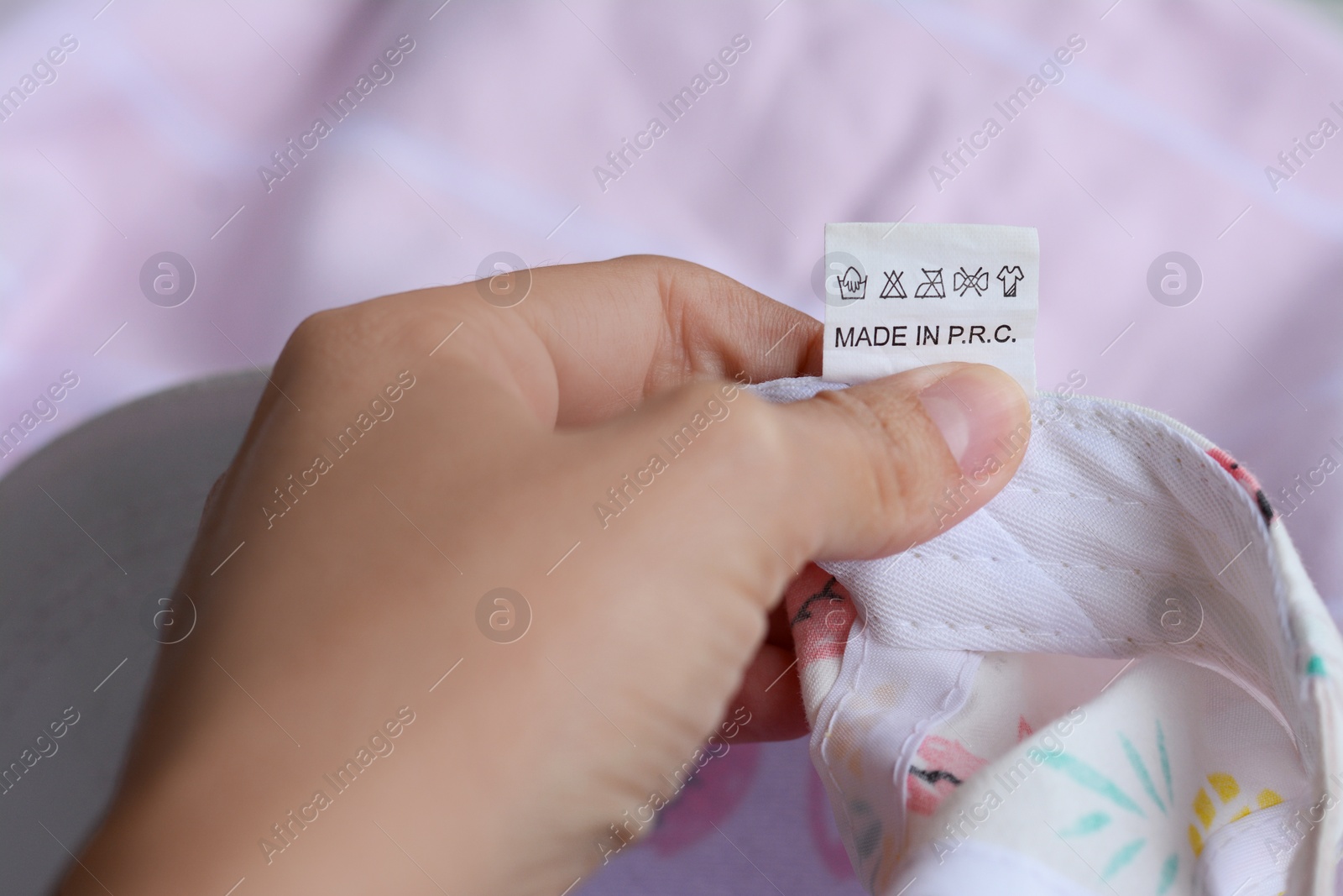 Photo of Woman holding clothing label on garment, closeup