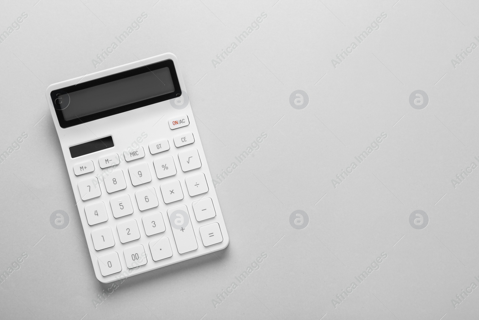 Photo of White calculator on light background, top view. Space for text