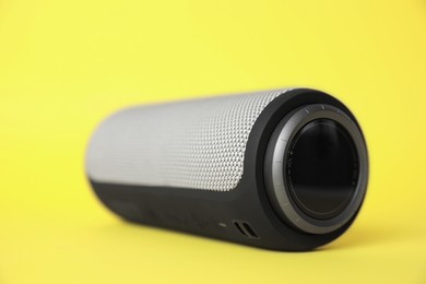 Photo of One portable bluetooth speaker on yellow background, closeup. Audio equipment