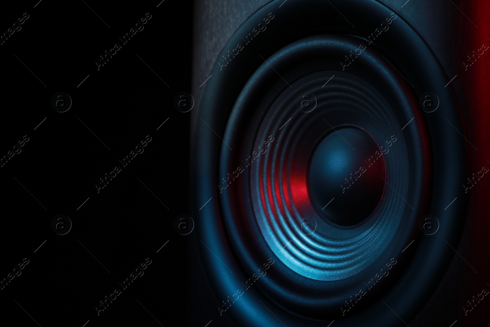 Photo of One sound speaker in neon light on black background, closeup. Space for text