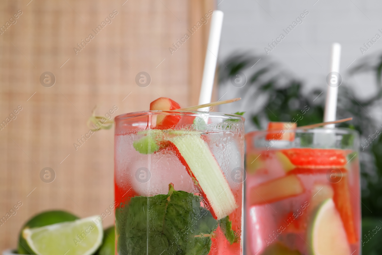 Photo of Tasty rhubarb cocktail with lime indoors, closeup