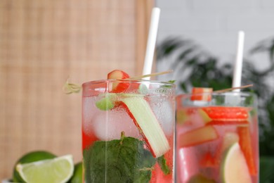 Photo of Tasty rhubarb cocktail with lime indoors, closeup