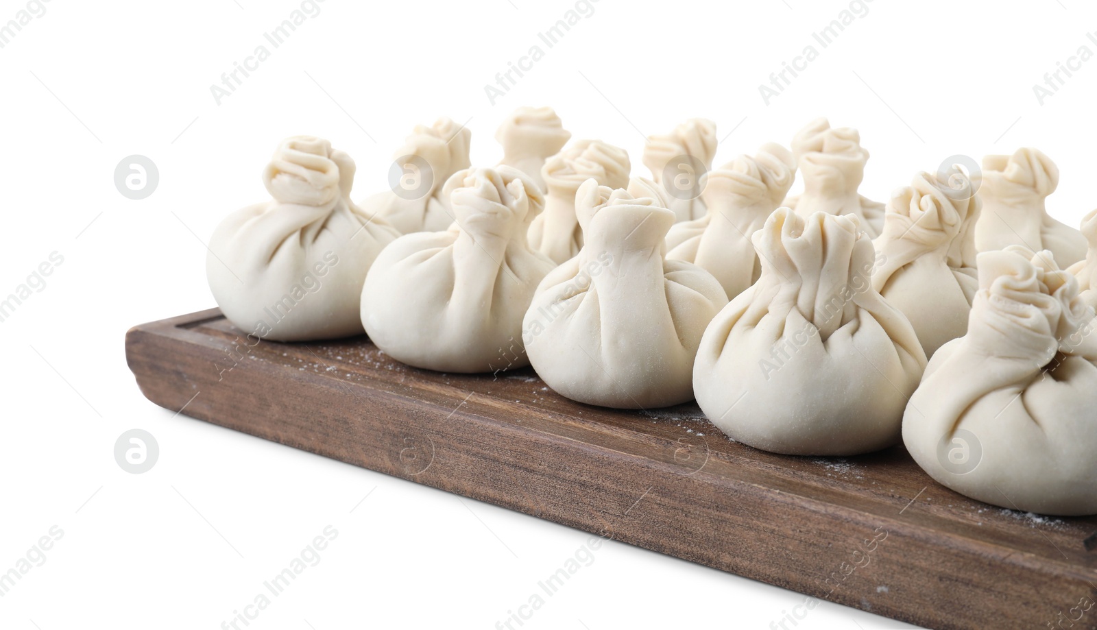 Photo of Wooden board with uncooked khinkali (dumplings) isolated on white. Georgian cuisine