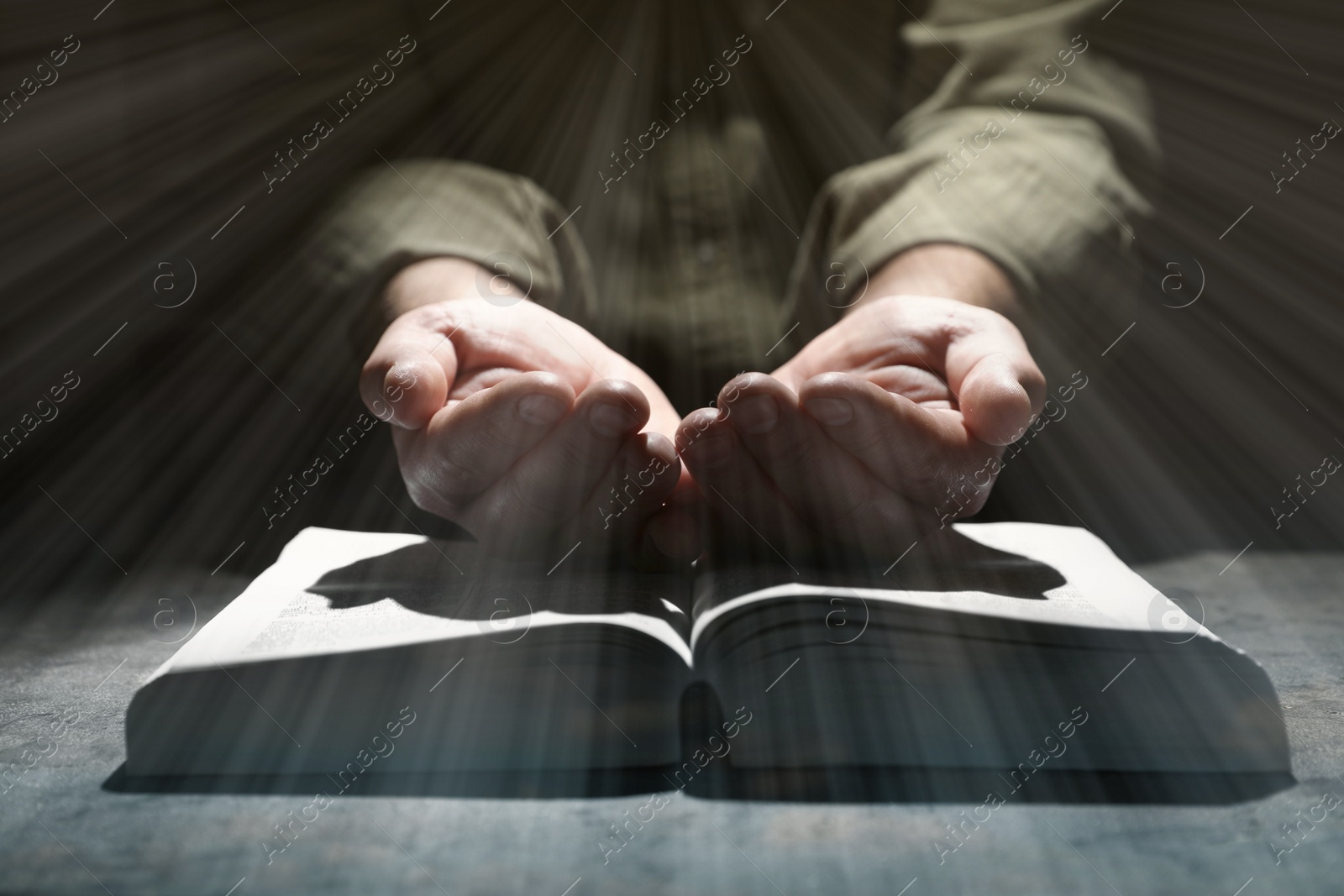 Image of Religion. Christian man praying over Bible at table, closeup