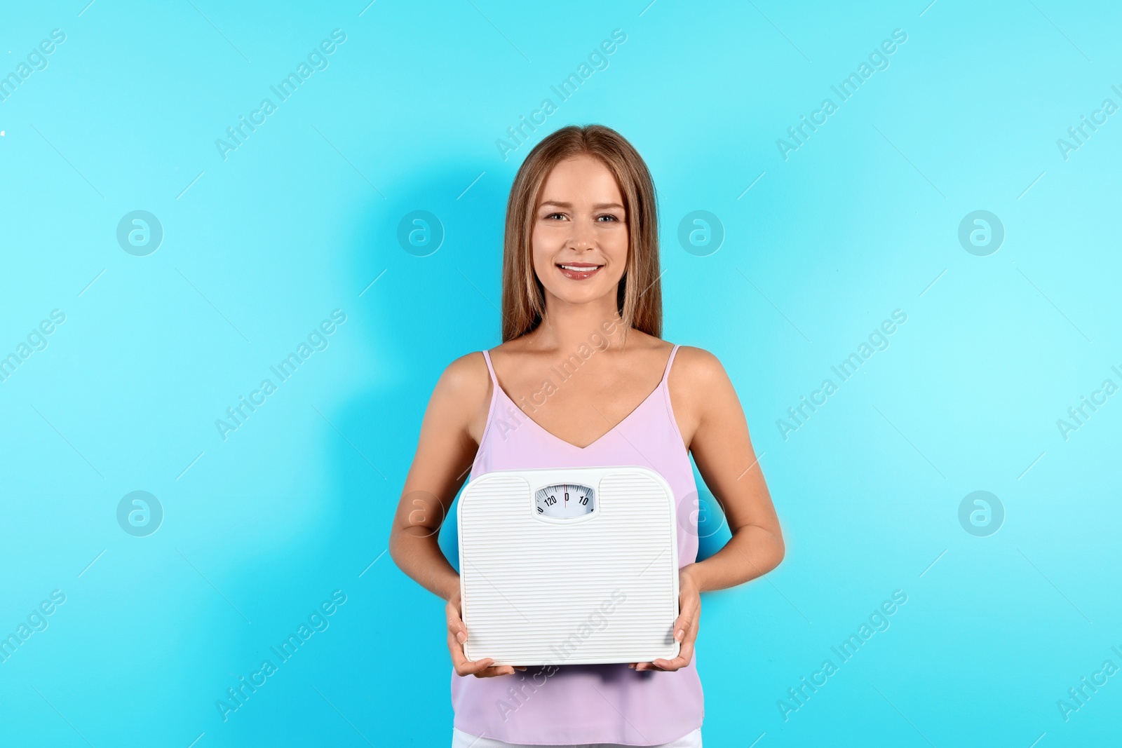 Photo of Slim woman with scale on color background. Healthy diet