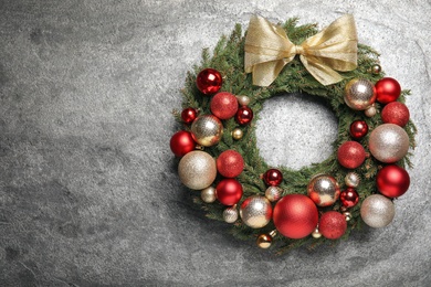 Photo of Beautiful Christmas wreath with festive decor on grey background. Space for text