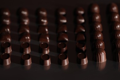 Photo of Many delicious chocolate candies on table. Production line