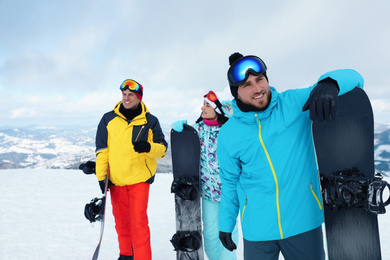 Photo of Group of friends with equipment in snowy mountains. Winter vacation