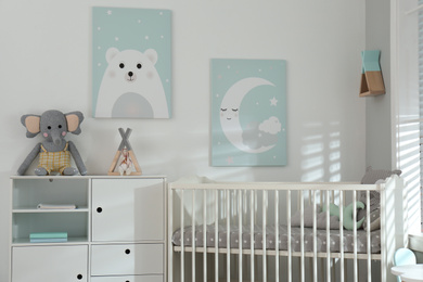 Photo of Stylish baby room interior with crib and cute wall art