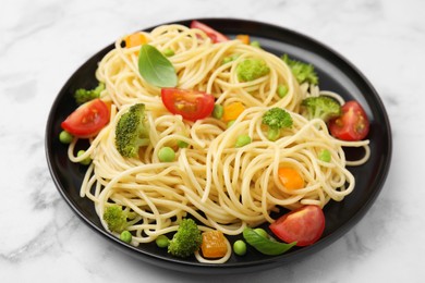 Photo of Plate of delicious pasta primavera on white marble table, closeup