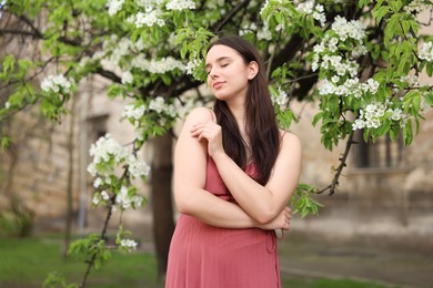 Photo of Beautiful woman near blossoming tree on spring day