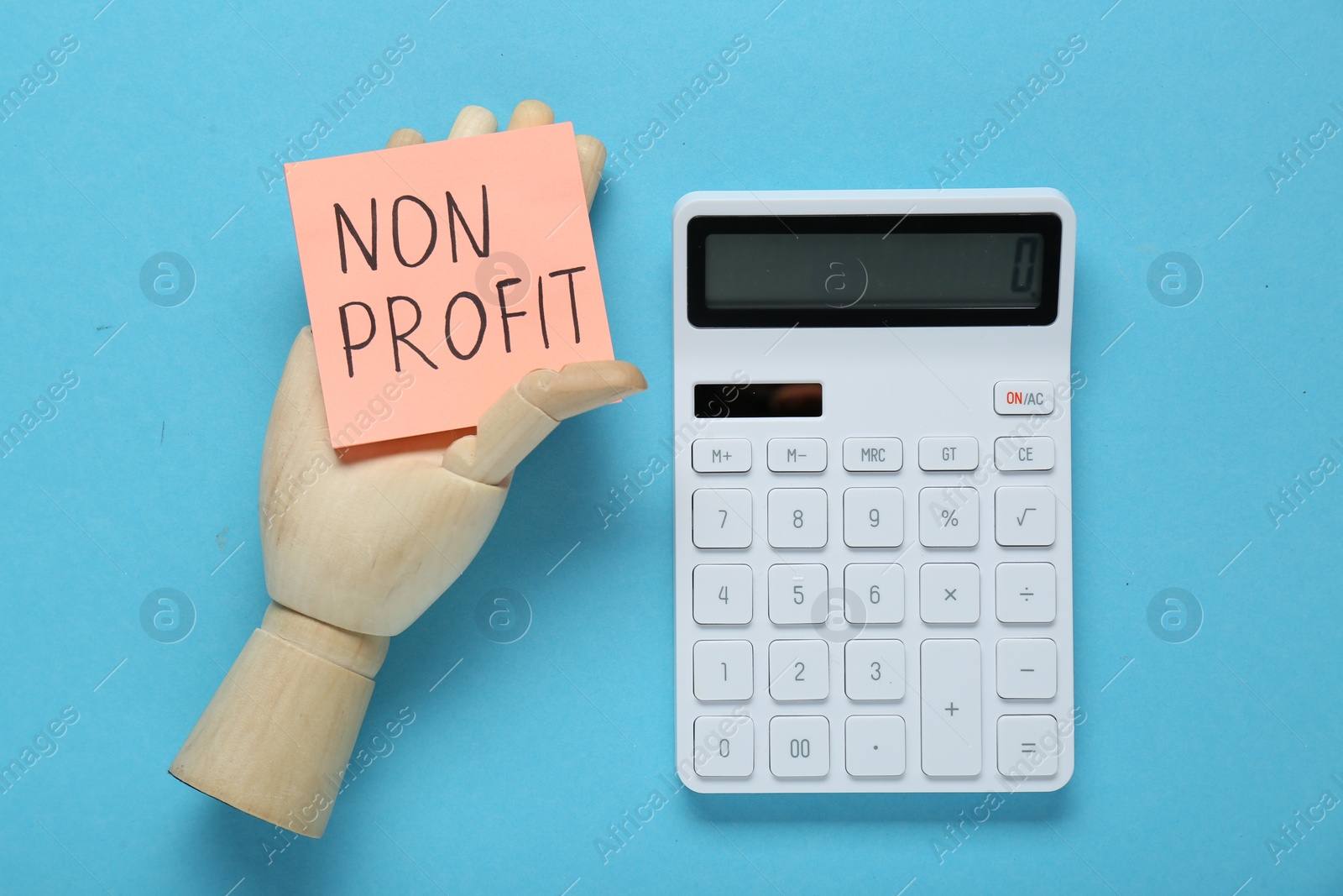 Photo of Non Profit concept. Flat lay composition with paper note in wooden mannequin hand on light blue background