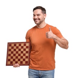 Smiling man holding chessboard and showing thumbs up on white background