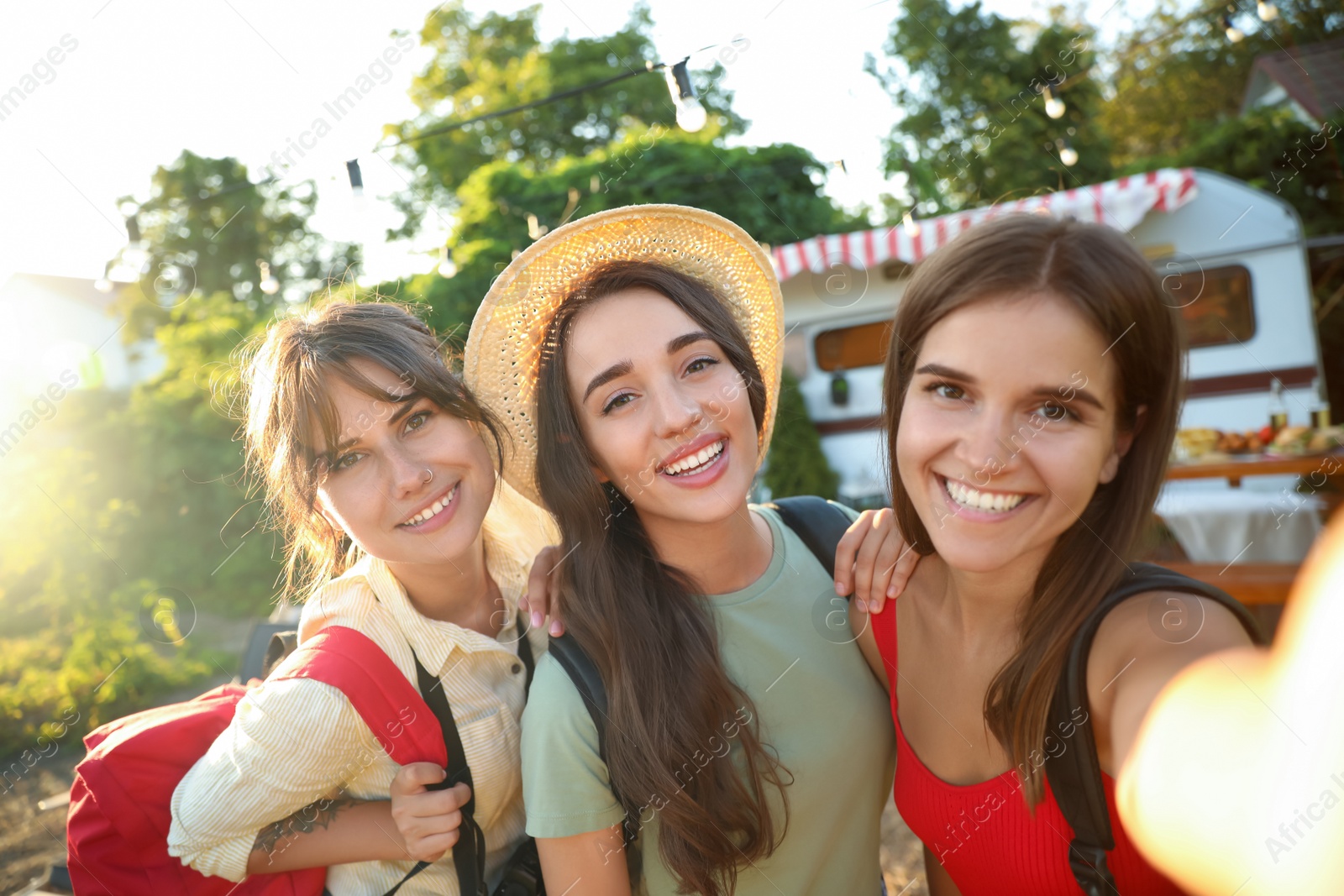 Photo of Young travelers with backpacks taking selfie outdoors. Summer trip