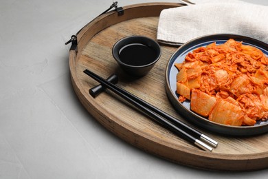 Delicious kimchi with Chinese cabbage and sauce on light grey table, space for text