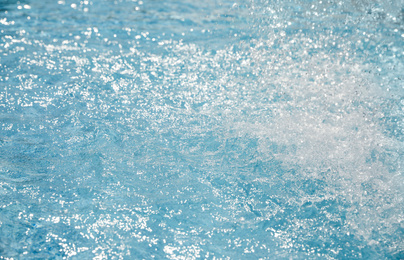 Photo of Splashes in swimming pool on sunny day. Summer vacation